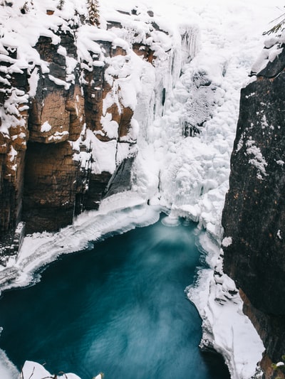 水体旁积雪覆盖的岩层